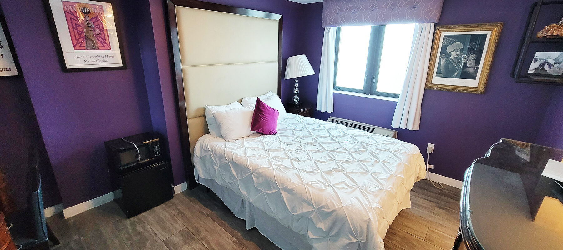 Ela Fitzgerald room. Kings size bed with leather head board in a room with purple walls
