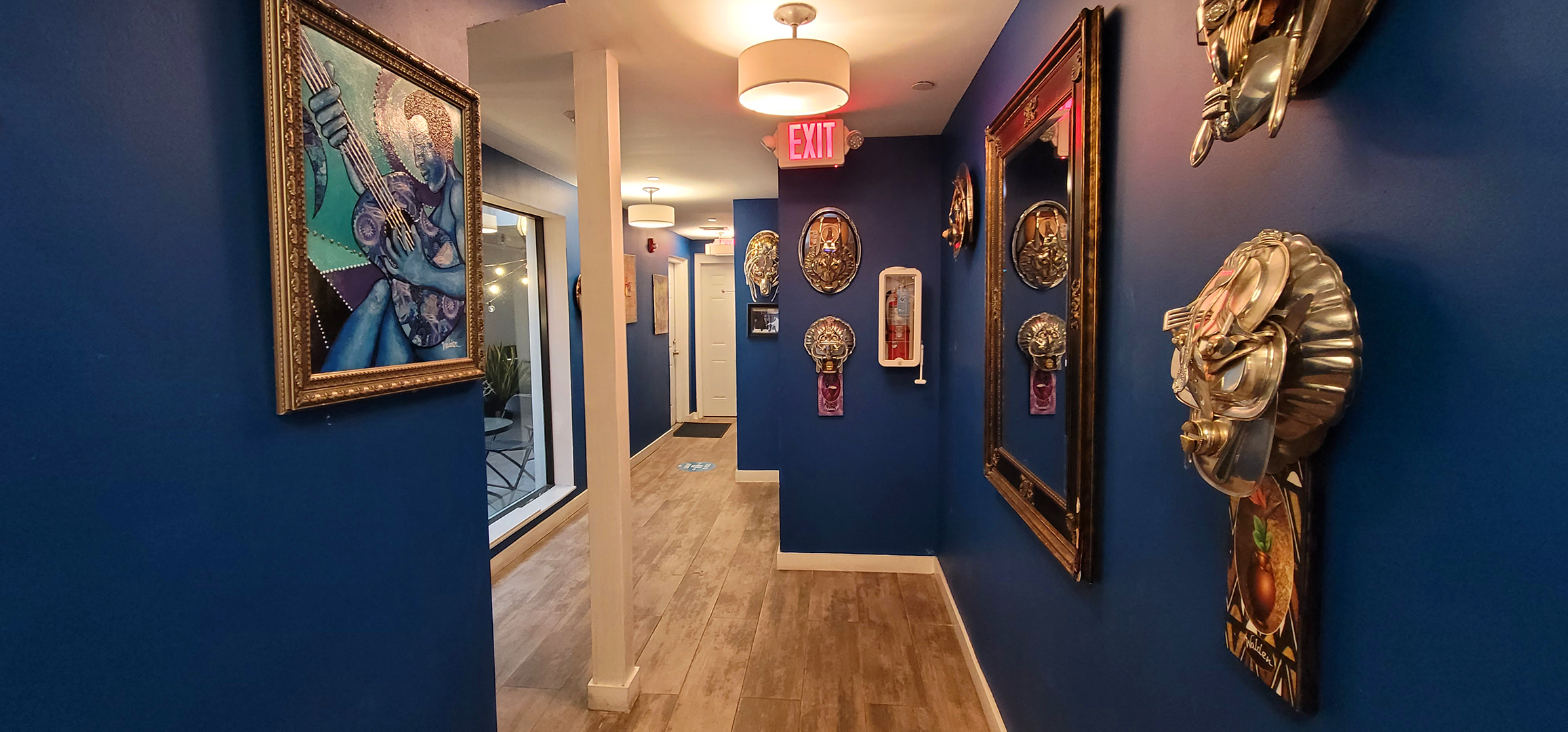 long blue hallway with painting and art-craft on the wall